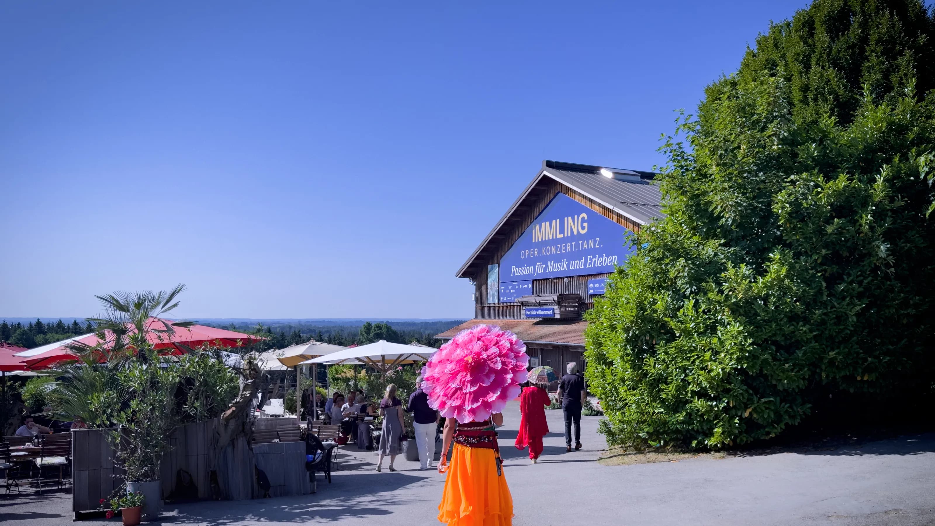 Orangene Besucherin mit Sonnenschirm